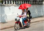 057. Ladies with umbrella on motor bike